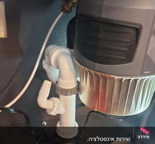 צנרת מתחת לכיור עם מחבר ומתקן סינון מים